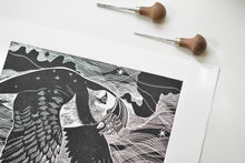 Load image into Gallery viewer, Black and white linocut print of a bird with carving tools on a white background