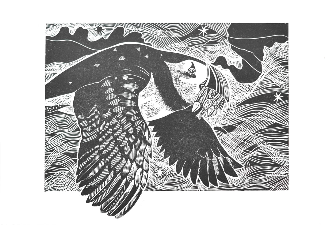 Black and white hand carved linoprint illustration of a puffin bird flying with a starry background 