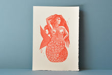 Load image into Gallery viewer, Red mermaid illustration on a white background against a blue wall
